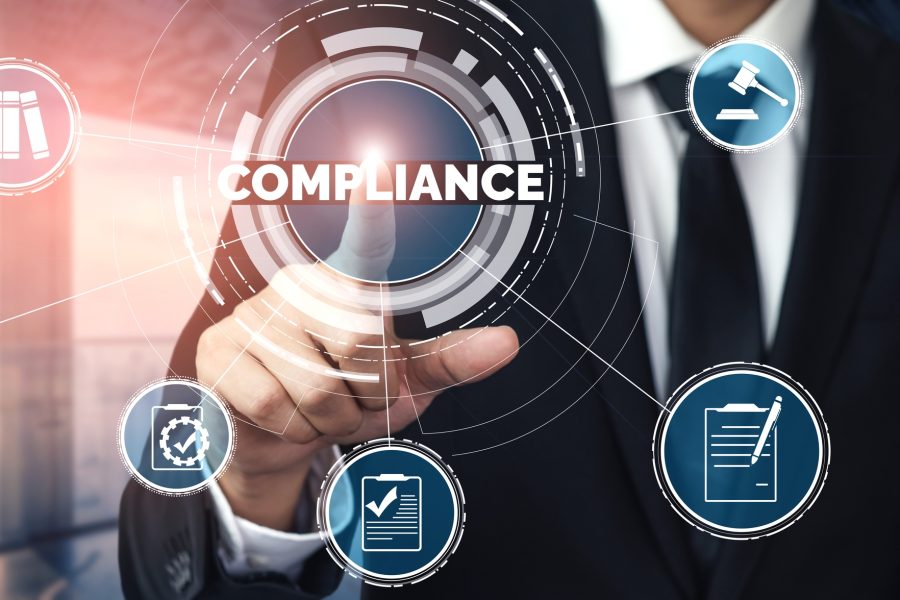 Mann i dress som peker på compliance-symbol