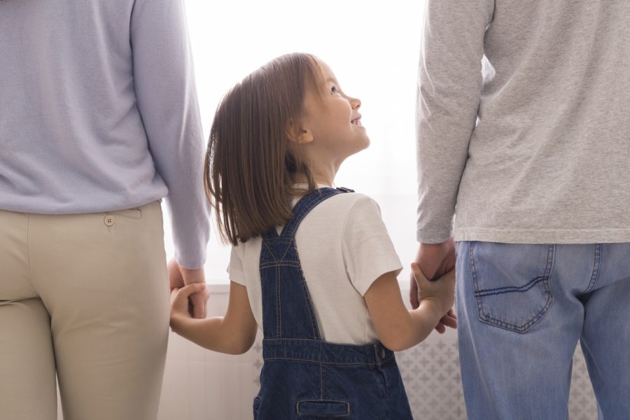 Bilde av to foreldre og et smilende barn