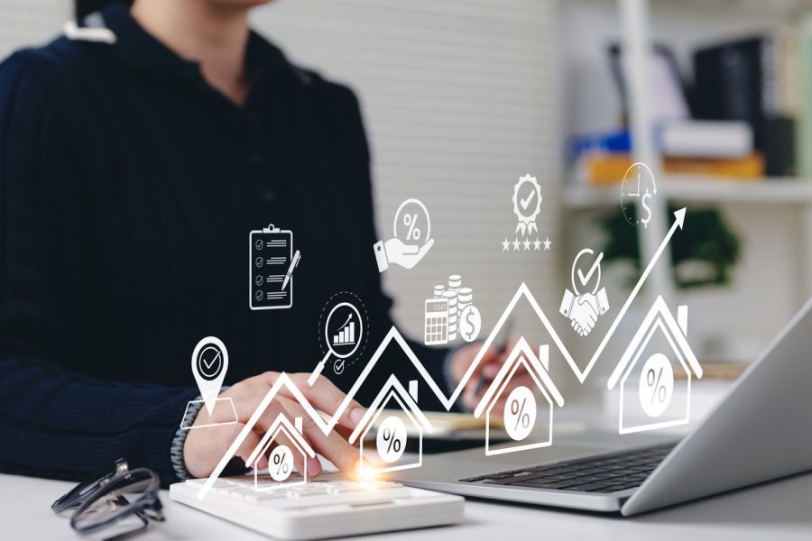 En person som sitter ved en pc, med illustrasjonsbilder av hus, graf og ikoner.